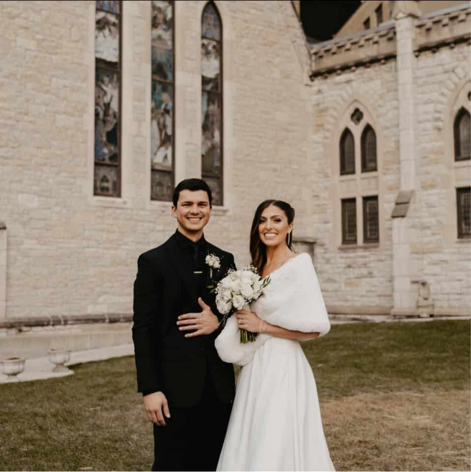 January Wedding Adam and Madi standing in front of Indianapolis cathedral 